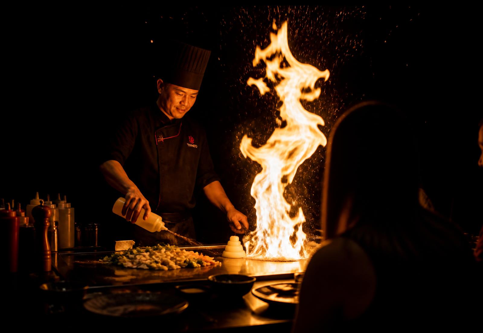 Hibachi chef sending flames up from the teppanyaki grill at Kumo 27 in Kendall Park, NJ